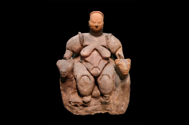 La femme assise de Catalhoyuk est assise de manière dominante entre deux léopards, tenant son siège (Creative Commons)