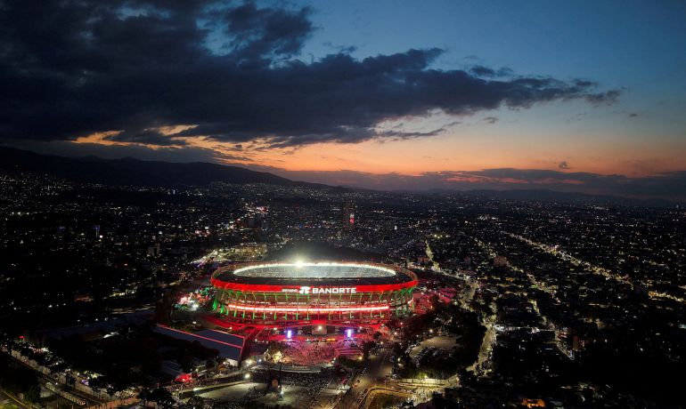 Le stade Azteca s'illumine au coucher du soleil avec des nuages ​​sombres au-dessus de sa tête