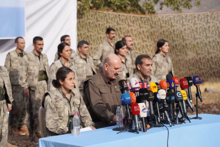 Des combattants du Parti des travailleurs du Kurdistan, qui se seraient retirés de Turquie avec leurs armes, se tiennent au garde-à-vous lors d'une cérémonie dans la région de Qandil, dans le nord de l'Irak, en 2025.