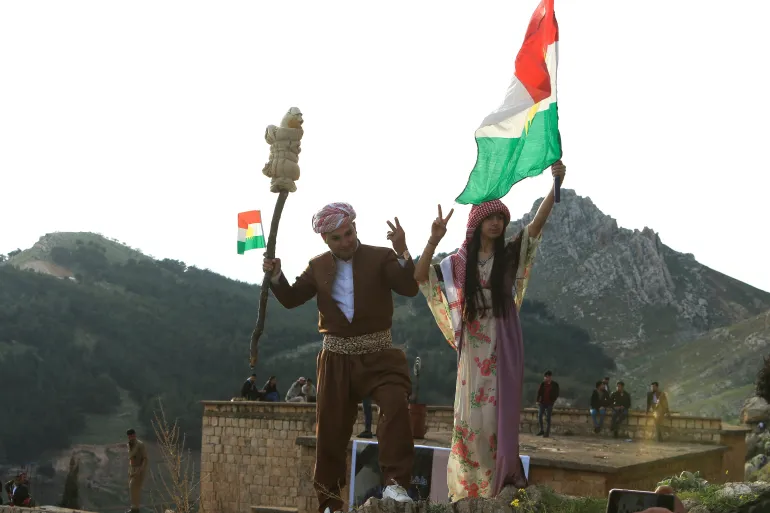 Les Kurdes irakiens brandissant des drapeaux kurdes célèbrent le jour de Nowruz, un festival marquant le premier jour du printemps et du nouvel an, au milieu de la propagation de la maladie à coronavirus (COVID-19), dans la ville d'Akra près de Duhok, au Kurdistan irakien.